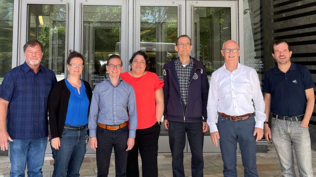 Group of scientists standing in front of glass doors